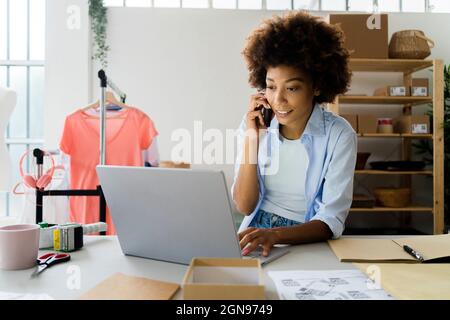 Femme de mode travaillant sur un ordinateur portable en studio Banque D'Images
