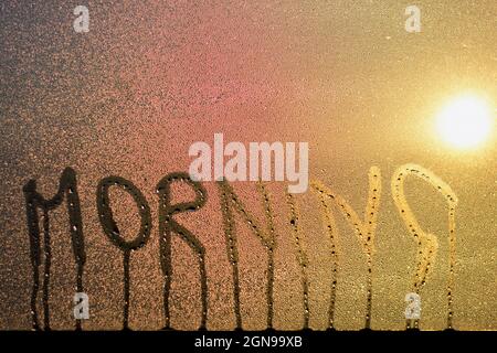 Gros plan du mot du matin sur la fenêtre en verre à condensation humide Banque D'Images