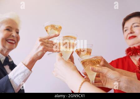 nouvel an célébrant les mains avec des verres de vin mousseux blanc. Noël, famille, amis, célébration, concept de la nouvelle année Banque D'Images