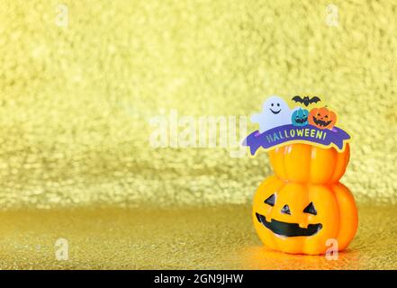 Photographie de studio représentant un sourire halloween Jack o lanterne tête de citrouille avec découpe en carton d'un fantôme drôle et chauves-souris avec le mot Halloween! Banque D'Images