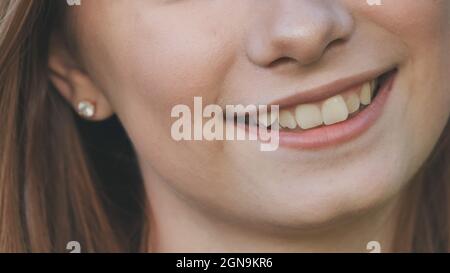 Une jeune fille sourit et montre ses dents torchées. Banque D'Images