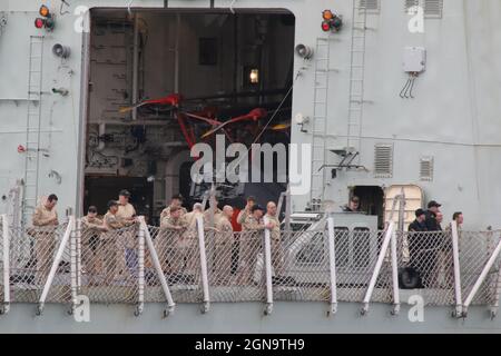 Certains membres de l'équipage se réunissent sur le pont de vol du NCSM Fredericton (FFH-337), une frégate de classe Halifax (ou de classe ville) exploitée par la Marine royale du Canada. Le navire est vu passer Greenock sur le Firth de Clyde, avant de participer aux exercices militaires Dynamic Mariner 2021 et joint Warrior 21-2. Banque D'Images