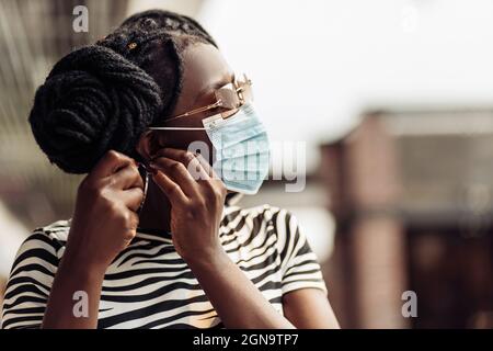 Femme afro-américaine portant un masque de protection médicale, jeune femme portant un masque de protection pour protéger contre le coronavirus, une femme portant un Banque D'Images