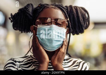 Femme afro-américaine portant un masque de protection médicale, jeune femme portant un masque de protection pour protéger contre le coronavirus, une femme portant un Banque D'Images