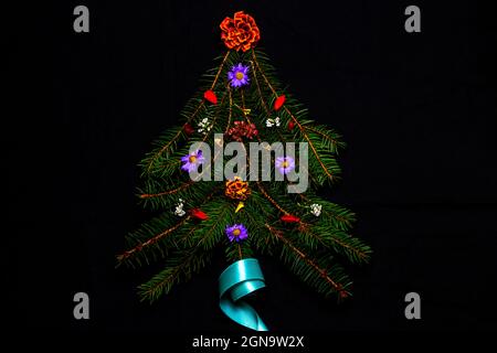 Forme d'arbre de Noël en branche de sapin enneigé avec différentes fleurs et ruban turquoise composition carrée, plat, vue de dessus épinette d'hiver Banque D'Images