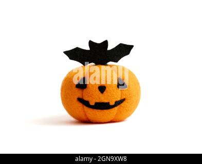 Citrouille d'Halloween avec une batte. Jouets de feutrage en laine isolés sur fond blanc. Banque D'Images