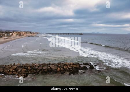 Tir de drone de faible altitude de la jetée en pierre avec jetée à distance, San Diego Californie Banque D'Images