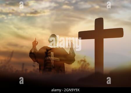 Silhouette de l'homme levant les mains adorez et louez Dieu. Concept de religion chrétienne. Banque D'Images