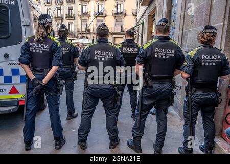 Des policiers de la Garde urbaine sont vus en train de surveiller l'une des entrées de la Plaza Sant Jaume devant des groupes de manifestants pendant la manifestation.divers groupes de citoyens ont protesté aux entrées de la Plaza Sant Jaime, qui a été encordonnée par la police conformément aux recommandations de la Les autorités sanitaires en raison de la pandémie de Covid-19, avec des sifflets et des cris appelant à la démission du maire Ada Colau lors de la lecture de la proclamation qui donne le début des festivités de la Mercè, patron saint de Barcelone. Banque D'Images