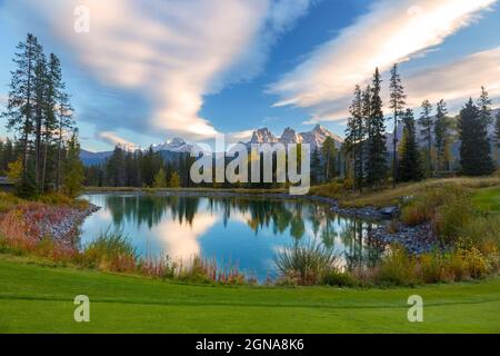 Météo nuages reflétés dans parcours de golf Calm Blue Water Lake. Green Grass lointain Mountain Peaks Horizon. Bow Valley Alberta Parc national Banff Banque D'Images