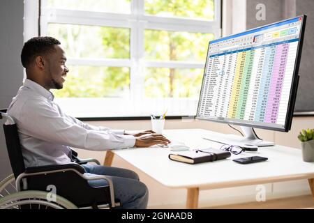 Feuille de calcul de codage médical sur PC. Homme africain en fauteuil roulant Banque D'Images