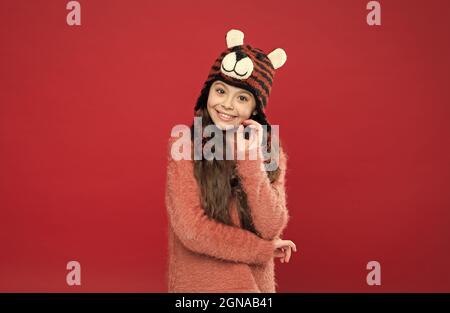 joyeux enfant dans des vêtements chauds d'hiver en tricot et chapeau à rabats prêt pour les activités de vacances, l'enfance Banque D'Images