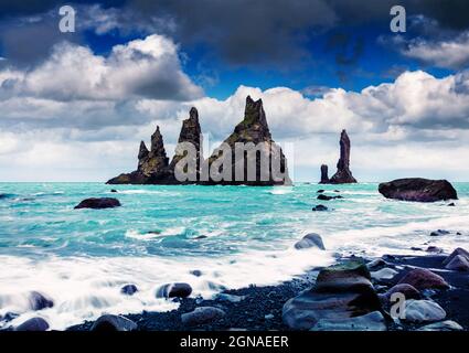 Paysage marin spectaculaire des falaises de Reynisdrangar dans l'océan Atlantique. Matin d'été nuageux dans le sud de l'Islande, village de Vic, Europe. Style artistique Banque D'Images