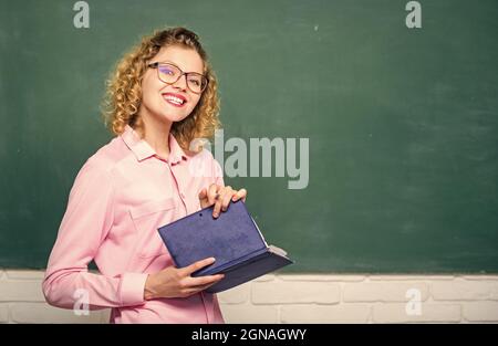 Le professeur explique le sujet dur. Pédalo tenir le livre et expliquer l'information. Concept d'éducation. Femme enseignante devant le tableau de surveillance. Enseignant Banque D'Images