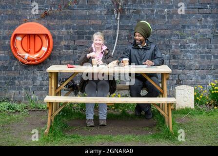 Les amis apprécient un café à Wallbridge Lock sur le canal de navigation Stroudwater dans la ville de Stroud à Gloucestershire, Royaume-Uni Banque D'Images