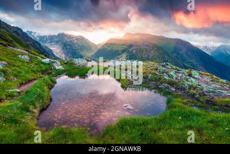 Lever de soleil spectaculaire en été près du lac Totensee, au sommet de Grimselpass. Magnifique scène en plein air dans les Alpes suisses, canton de Berne, Suisse, Europe. Banque D'Images