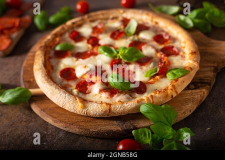 Pizza délice avec salami chaud, parmesan et basilic frais Banque D'Images