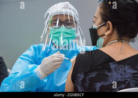 Bangkok, Thaïlande. 24 septembre 2021. Un agent de santé administre une dose du vaccin AstraZeneca COVID-19 à une femme de la gare Bang Sue Grand Station de Bangkok. Le Gouvernement thaïlandais prévoit de rouvrir le pays d'ici le 1er octobre 2021 a été repoussé au 1er novembre 2021.moins de 70 pour cent de ses résidents ont encore été vaccinés contre Covid-19 à Bangkok. Le Gouvernement thaïlandais a déclaré qu'il faudrait vacciner au moins 70 pour cent de la population avant de rouvrir le pays pour le tourisme étranger. Crédit : SOPA Images Limited/Alamy Live News Banque D'Images