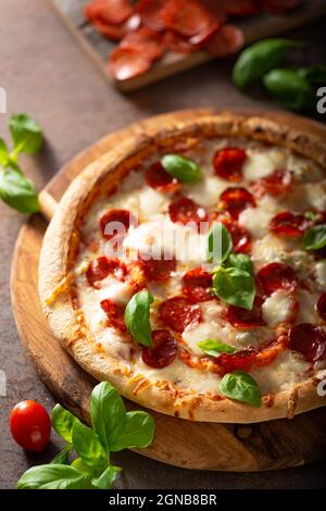 Pizza délice avec salami chaud, parmesan et basilic frais Banque D'Images