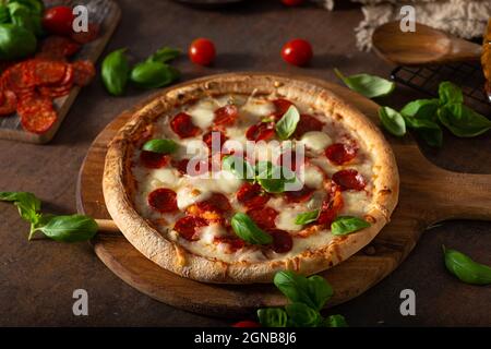 Pizza délice avec salami chaud, parmesan et basilic frais Banque D'Images