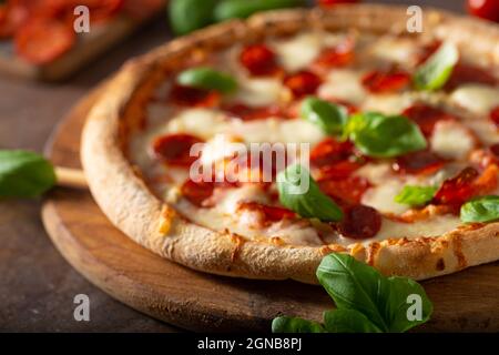 Pizza délice avec salami chaud, parmesan et basilic frais Banque D'Images