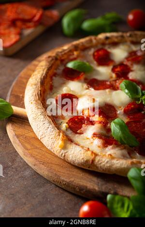 Pizza délice avec salami chaud, parmesan et basilic frais Banque D'Images