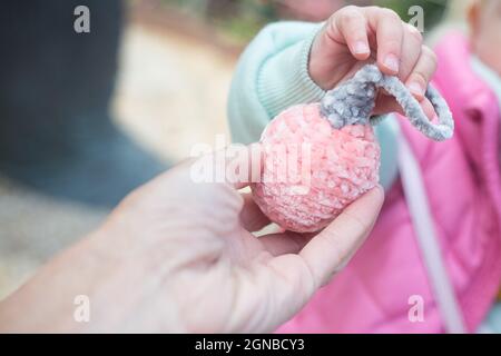 Mère donne à bébé nouvel an boule amigurumi.Tricoté en fil de peluche doux pour la décoration de Noël.Cadeaux de Noël faits main.Faire un cadeau Banque D'Images