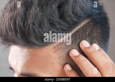jeune homme avec des cheveux de coiffage gros plan Banque D'Images