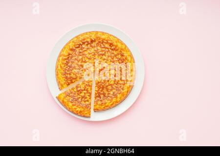 Gâteau de riz au lait, tarte ronde avec une tranche, pâtisserie comme dessert, composition minimale, vue de dessus Banque D'Images