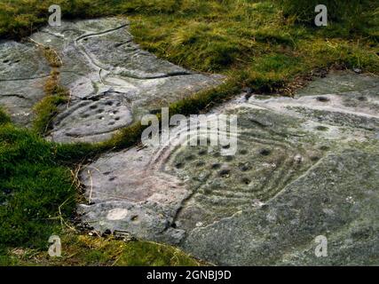 Regardez E de l'art rupestre préhistorique sur DoD Law, Northumberland, Angleterre, Royaume-Uni, montrant des cupmarks à l'intérieur des enclos ou des cadres délimités par des rainures. Banque D'Images