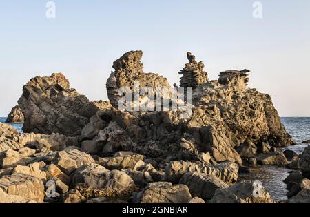 Le Faragghiuneddi, un affleurement volcanique surréaliste de lave dans la ville d'ACI Trezza, Catane, Sicile, Italie, près de l'Isole dei Ciclopi (les Faraglioni) Banque D'Images