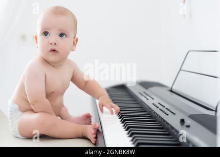 bébé garçon, jouer du piano à la maison, apprentissage des enfants Banque D'Images