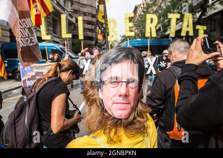 Un manifestant porte un masque avec un visage de l'ancien président de la Generalitat de Catalogne, Carles Puigdemont pendant la manifestation.des groupes d'indépendance catalanes manifestent en dehors du consulat italien à Barcelone après l'arrestation de l'ancien président catalan exilé Carles Puigdemont en Italie. Banque D'Images