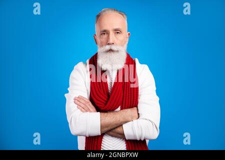 Photo d'un homme mûr assez sérieux habillé blanc pull-over rouge foulard mains repliées isolé couleur bleu fond Banque D'Images