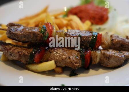 Brochettes de porc sur brochettes de bois avec légumes et pommes de terre frites. Banque D'Images