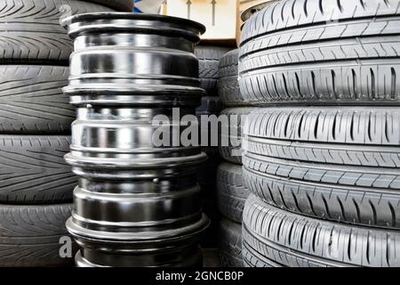 Pile de pneus et jantes de roues dans un garage d'atelier de réparation automobile. Banque D'Images