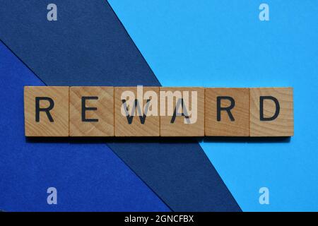 Récompense, mot en lettres de l'alphabet en bois isolées sur fond bleu comme titre de bannière avec espace de copie Banque D'Images