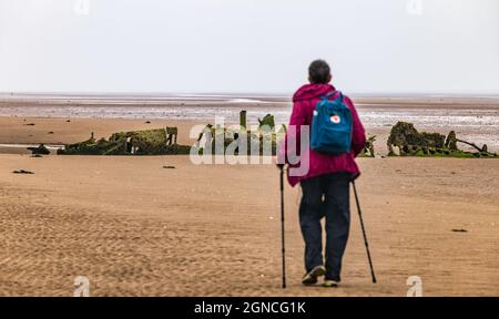 Marcheur plus âgé regardant le sous-marin Midget de classe XT de la Seconde Guerre mondiale enterré dans le sable à marée basse, Aberlady Bay, East Lothian, Écosse, Royaume-Uni Banque D'Images