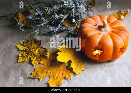 citrouille avec bougies et feuilles d'automne. Lanterne avec bougies allumées et mousse sèche sur les branches Banque D'Images