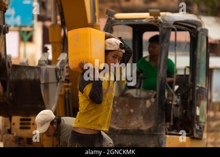 Indein Village, Myanmar - 05 janvier 2020 : Portrait d'un jeune homme travaillant sur un chantier de construction, porte du sable dans un seau, État Shan Banque D'Images