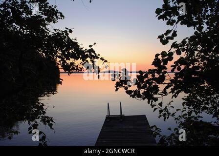 Quai de baignade entouré de bouleaux sur le lac Karjalan Pyhäjärvi, dans l'est de la Finlande, au coucher du soleil. Banque D'Images