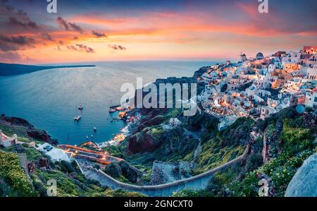 Vue impressionnante en soirée sur l'île de Santorini. Pittoresque coucher de soleil de printemps sur la célèbre station grecque Oia, Grèce, Europe. Présentation du concept de déplacement. A Banque D'Images