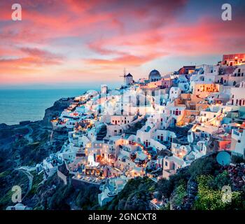 Vue impressionnante en soirée sur l'île de Santorini. Pittoresque coucher de soleil de printemps sur la célèbre station grecque Oia, Grèce, Europe. Présentation du concept de déplacement. A Banque D'Images