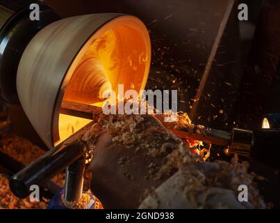 Un bol en bois étant tourné par un homme sur un tour de tourneurs.Un artisan au travail.Sawdust vole. Banque D'Images