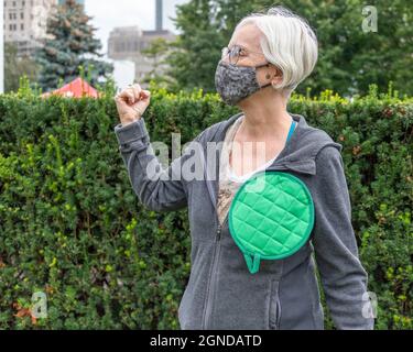 Femme senior avec un article de tissu de cuisine vert comme un bouton d'épingle lors de la Marche mondiale du climat organisée par les vendredis pour l'avenir devant la Provincia Banque D'Images