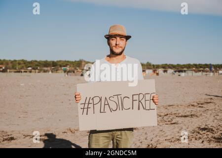 Activiste collectant des déchets plastiques sur la plage. Les gens nettoyant la plage, avec des sacs. Concept de la conservation de l'environnement et de la pollution des océans Banque D'Images