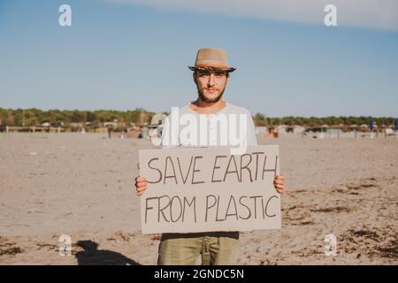 Activiste collectant des déchets plastiques sur la plage. Les gens nettoyant la plage, avec des sacs. Concept de la conservation de l'environnement et de la pollution des océans Banque D'Images