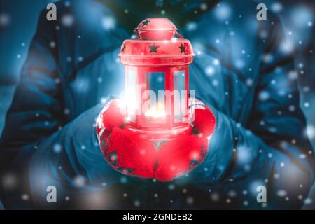 Homme tenant une lanterne rouge avec une bougie gros plan Banque D'Images