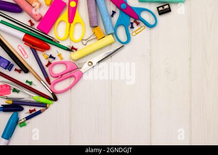 Fournitures scolaires colorées sur fond blanc en bois, . Vue de dessus. Copier l'espace. Éducation et concept de retour à l'école. Banque D'Images