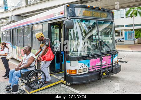 Miami Florida, Omni bus Station arrêt de bus Metrobus, fauteuil roulant électrique handicapés, Black man femme couple ADA plan d'accès Banque D'Images